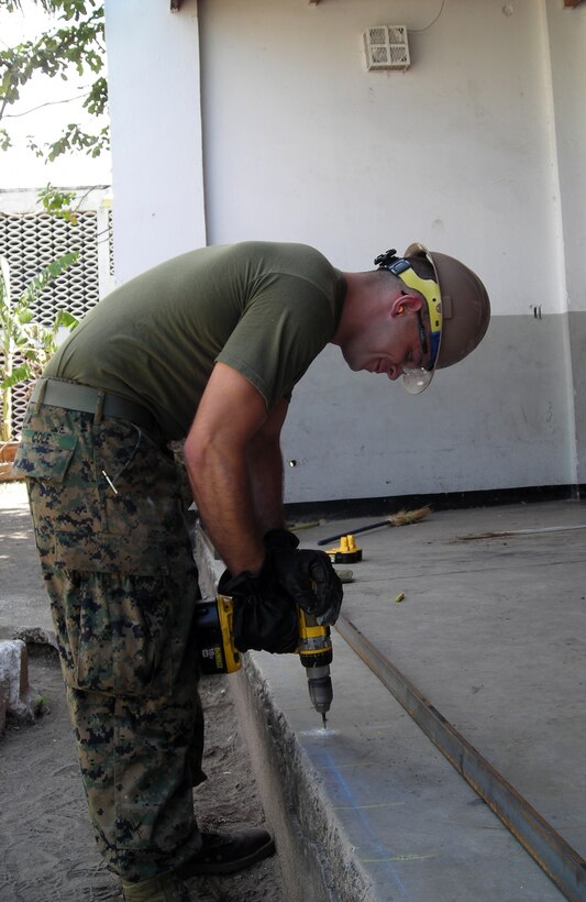 Lance Cpl. Steven B. Chole, a combat engineer with 8th Engineer Support Battalion, 2nd Marine Logistics Group, drills a hole during Operation Continuing Promise in Jamaica, which took place from April to September 2011. The five-month operation made stops in nine different countries.  (Courtesy Photo)