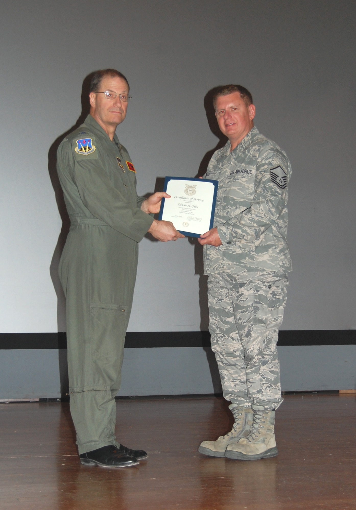 NELLIS AIR FORCE BASE, Nev. -- (Right) Master Sgt. Edwin Giles, 926th Aircraft Maintenance Squadron tactical aircraft maintenance technician, is presented with a certificate of service for 30 years of service in the government of the United States by Col. Herman Brunke, 926th GP commander, during a commander's call here April 2. (U.S. Air Force photo/Capt. Jessica Martin)