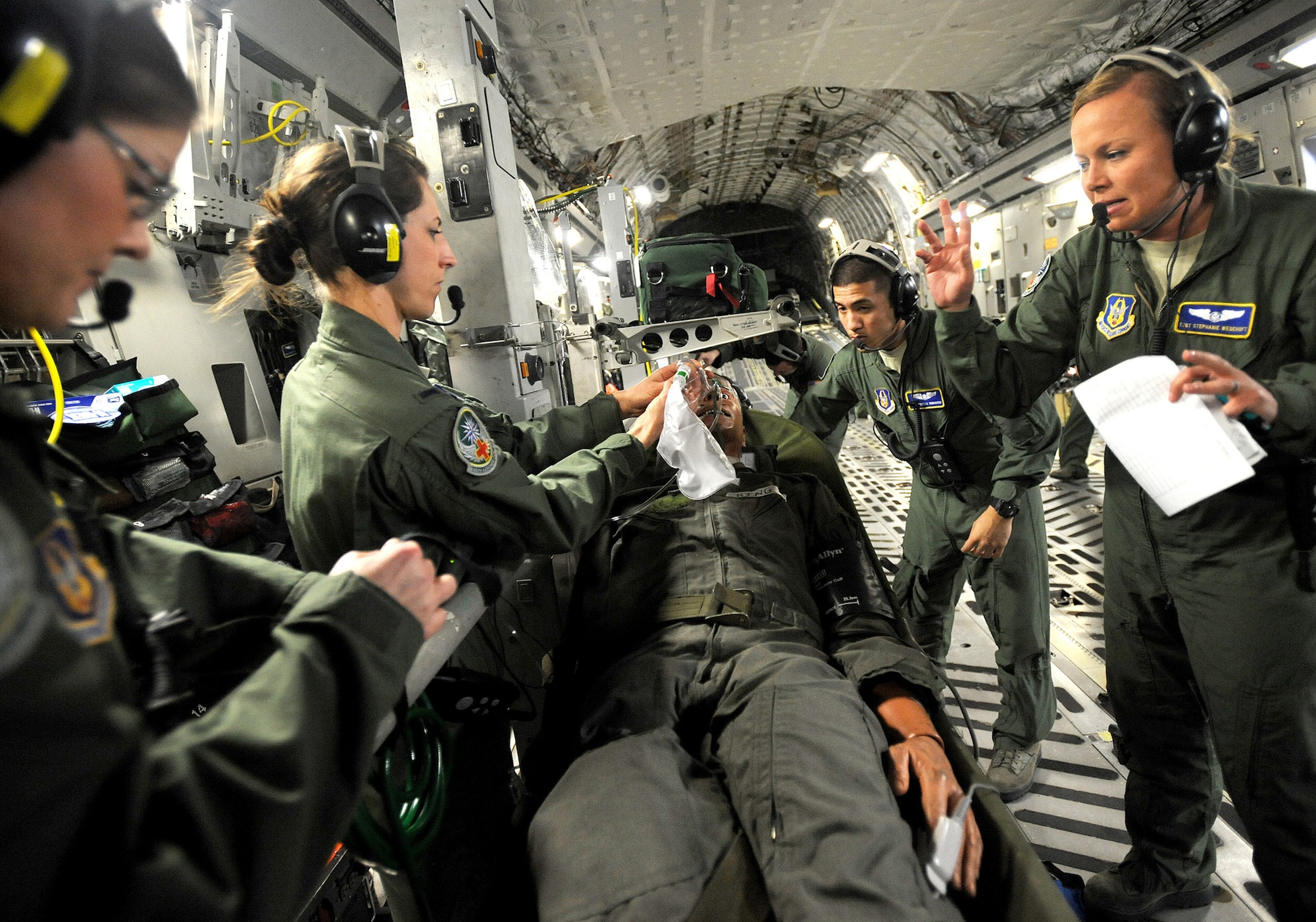 Air Force Reserve 2nd Lt. Kimmie Marin, left, 1st Lt. Amy Swaim, Senior Airman Marcello Yamaguchi, and Tech. Sgt. Stephanie Wegehoft, all with 446th Aeromedical Evacuation Squadron, McChord Field, Wash., work to revive Bing - a patient in cardiac arrest - during a training flight March 31 aboard a C-17 Globemaster III over Washington state. (U.S. Army photo by Ingrid Barrentine)
