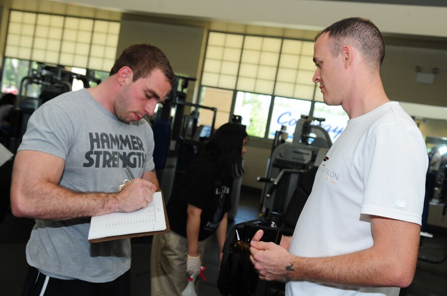 Michael Kaplan, 2nd Force Support Squadron Barksdale Fitness Center director, registers Tech. Sgt. John Robertson, 49th Test and Evaluation Squadron, for the Maxed-Out Friday bench press competition, April 15. Each entrant was given three opportunities to attempt to bench press his or her own weight or more. Each successful individual was awarded a T-shirt. (U.S. Air Force photo/Senior Airman Joanna M. Kresge))