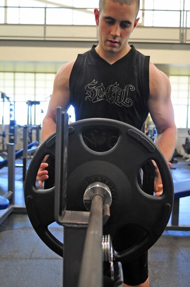 Airman 1st Class Ryan Menetrey, 26th Operational Weather Squadron, adds weights to a bench press bar during the Maxed-Out Friday competition at the Fitness Center located on Barksdale Air Force Base, La., April 15. Each entrant was given three opportunities to attempt to bench press his or her own weight or more. Each successful individual was awarded a T-shirt. (U.S. Air Force photo/Senior Airman Joanna M. Kresge)