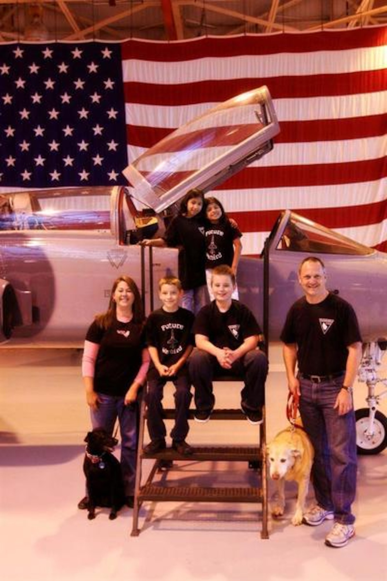 The family of Maj. Marc Mathes poses in front of a T-38 Talon at Vance Air Force Base. Pictured are (top, from left) Faith and Allie, both 9; (bottom, from) Kerry, Samuel, 10, Demitry, 12, and Mathes. The dogs are Bristol and Boomer. (Photo courtesy of Christa Elza)