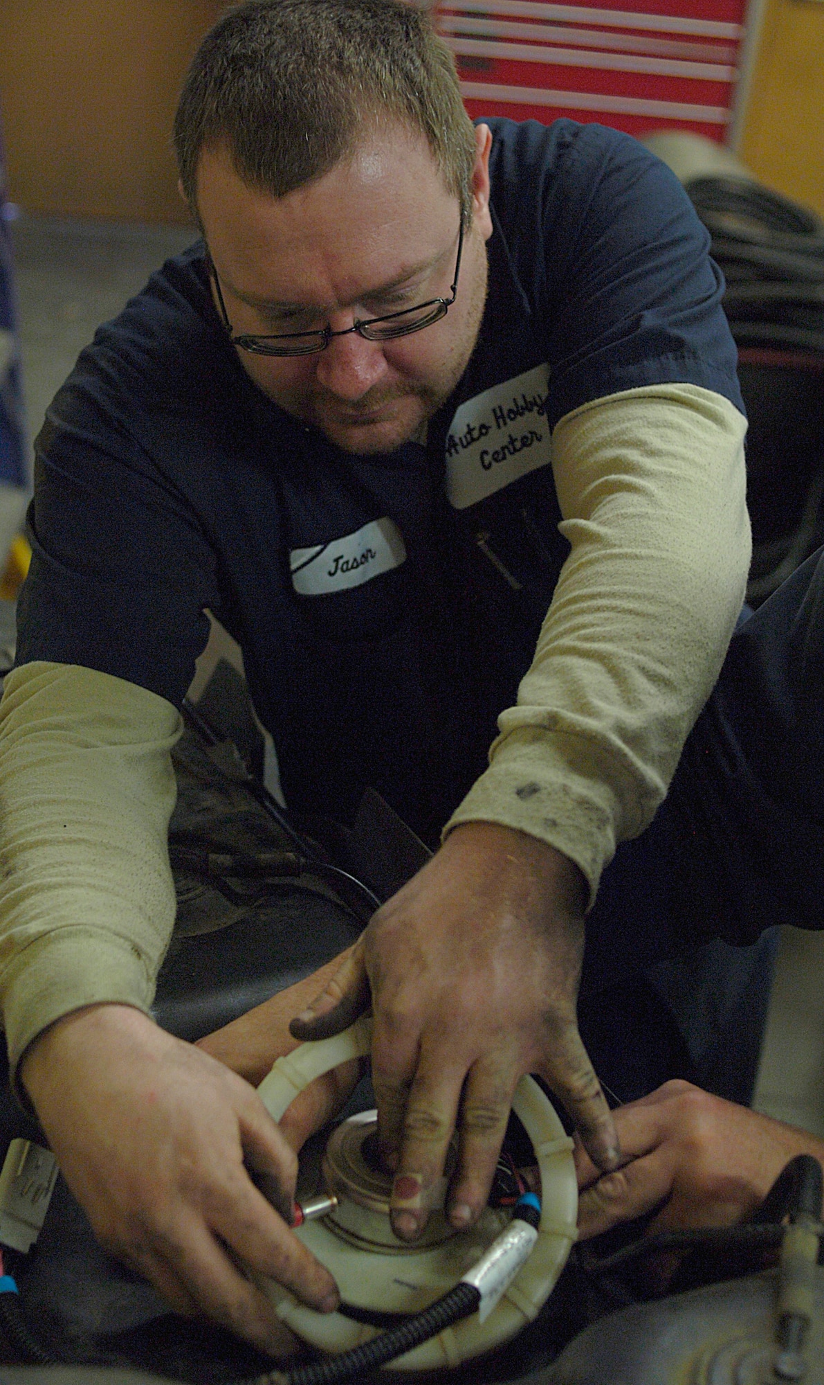 Staff Sgt. Jason Grivois replaces a fuel pump March 22 at the auto hobby center at Fairchild Air Force Base, Wash. He is an auto technician at the center as well as a power production technician with the 256th Combat Communications Squadron, Air National Guard. (U.S. Air Force Photo/Senior Airman Natasha Stannard)
