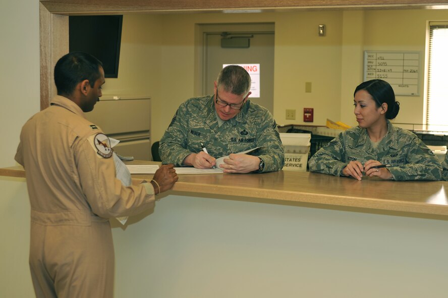 Capt. Calvin D'Silva, 92nd Operations Group pilot, is helped with inprocessing from a deployment by Senior Master Sgt. Scott Weber, 92nd Force Support Squadron personnel readiness superintendent, and Senior Airman Jennifer Acton, 92nd Comptroller Squadron financial technician. In order for Fairchild Air Force Base, Wash., personnel to deploy, the need to be up-to-date 'green' in the Preventative Health Assessment and Individual Medical Readiness program. (U.S. Air Force Photo/Tech. Sgt. Henry Hoegen) 