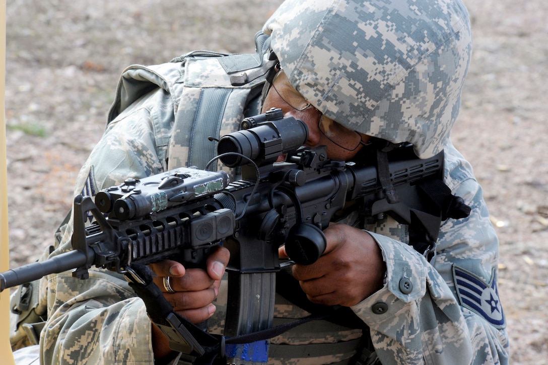 Staff Sgt. Monte McNeil, 28th Security Forces Squadron base defense operations center controller, takes aim as his partner moves forward during “Shoot, Move and Communicate,” training at April 13, 2011, at Ellsworth Air Force Base. The training helped Airmen learn to provide effective suppressive cover fire while efficiently communicating in a combat environment. (U.S. Air Force photo/Senior Airman Adam Grant)
