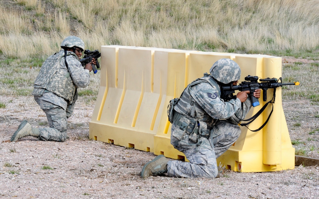 Members of the 28th Security Forces Squadron take cover behind a barrier during “Shoot, Move and Communicate,” training April 13, 2011, at Ellsworth Air Force Base. During this training, Security Forces members are critiqued on their response to hostile fire as well as their ability to communicate and effectively put rounds on target. (U.S. Air Force photo/Senior Airman Adam Grant)