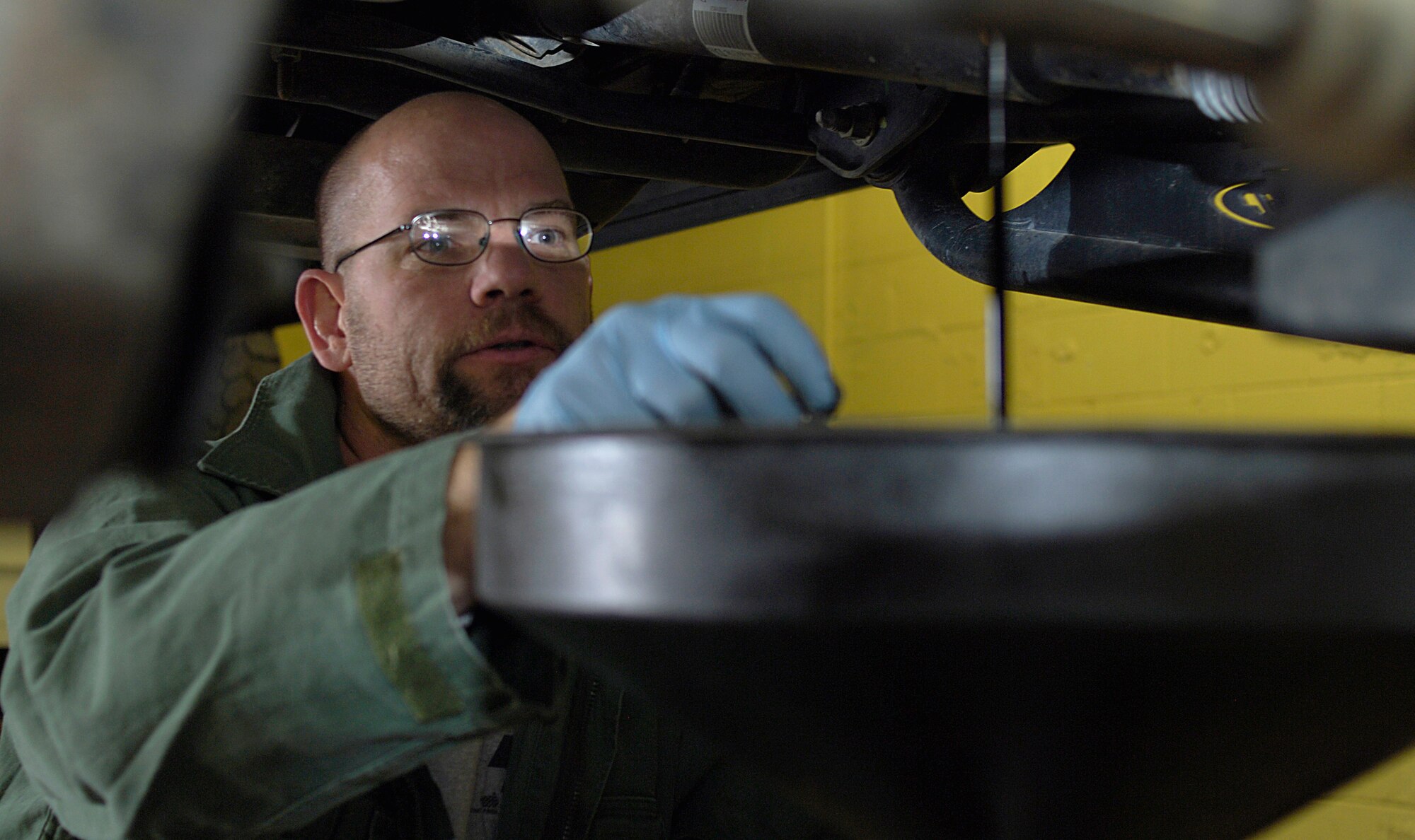 Andrew Haynes, customer, drains old oil from his vehicle March 22 at the auto hobby center at Fairchild Air Force Base, Wash. Mr. Haynes is visiting from Southern California. (U.S. Air Force Photo/Senior Airman Natasha Stannard)
