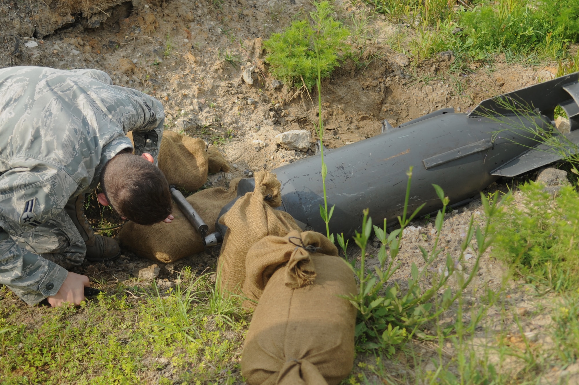 Airman 1st Class Rockwood Bullard, 23rd Civil Engineer Squadron explosive ordnance disposal apprentice, performs initial render safe procedures before securing a field fabricated de-armor device at Moody Air Force Base, Ga., April 15. This device was used to disarm the fuse and prevent it from detonating. (U.S. Air Force photo/Airman 1st Class Douglas Ellis)(RELEASED)
