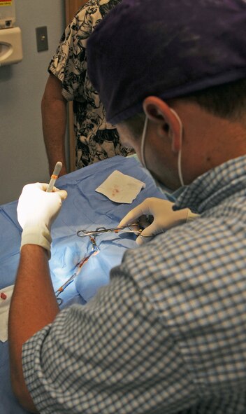 Veterinarian Dr. Darrin Olson sutures stitches to a canine after performing a castration at the vet clinic on Barksdale Air Force Base, La., April 13. The clinic performs parasite testing, vaccinations, routine dental procedures and surgeries, heartworm testing, micro-chipping and spays and neuters. More information about the Barksdale Vet Clinic can be found at www.barksdaleservices.com by selecting vet clinic under the Airman and family tab. (U.S. Air Force photo/Airman 1st Class Micaiah Anthony) (RELEASED)