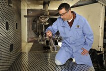 David Anderson, ATA test project engineer, inspects the 1/20-scale models of an F-15E Strike Eagle aircraft and a sting-mounted Small Diameter Bomb (SDB II), during a break in the ongoing store separation test for the new weapon’s development phase trials in the aerodynamic wind tunnel 4T of the Propulsion Wind Tunnel (PWT) facility. The test marks the second time the SDB II has been tested at Arnold. (Photo by Rick Goodfriend)