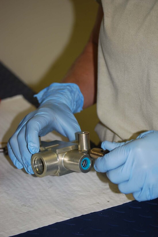Staff Sgt. Kelly Booth, a 433rd Maintenance Squadron hydraulic specialist, overhauls a snubber valve. The snubber valve prevents pressure build-up from damaging the aircraft. (U.S. Air Force photo/ Senior Airman Viola M. Hernandez)