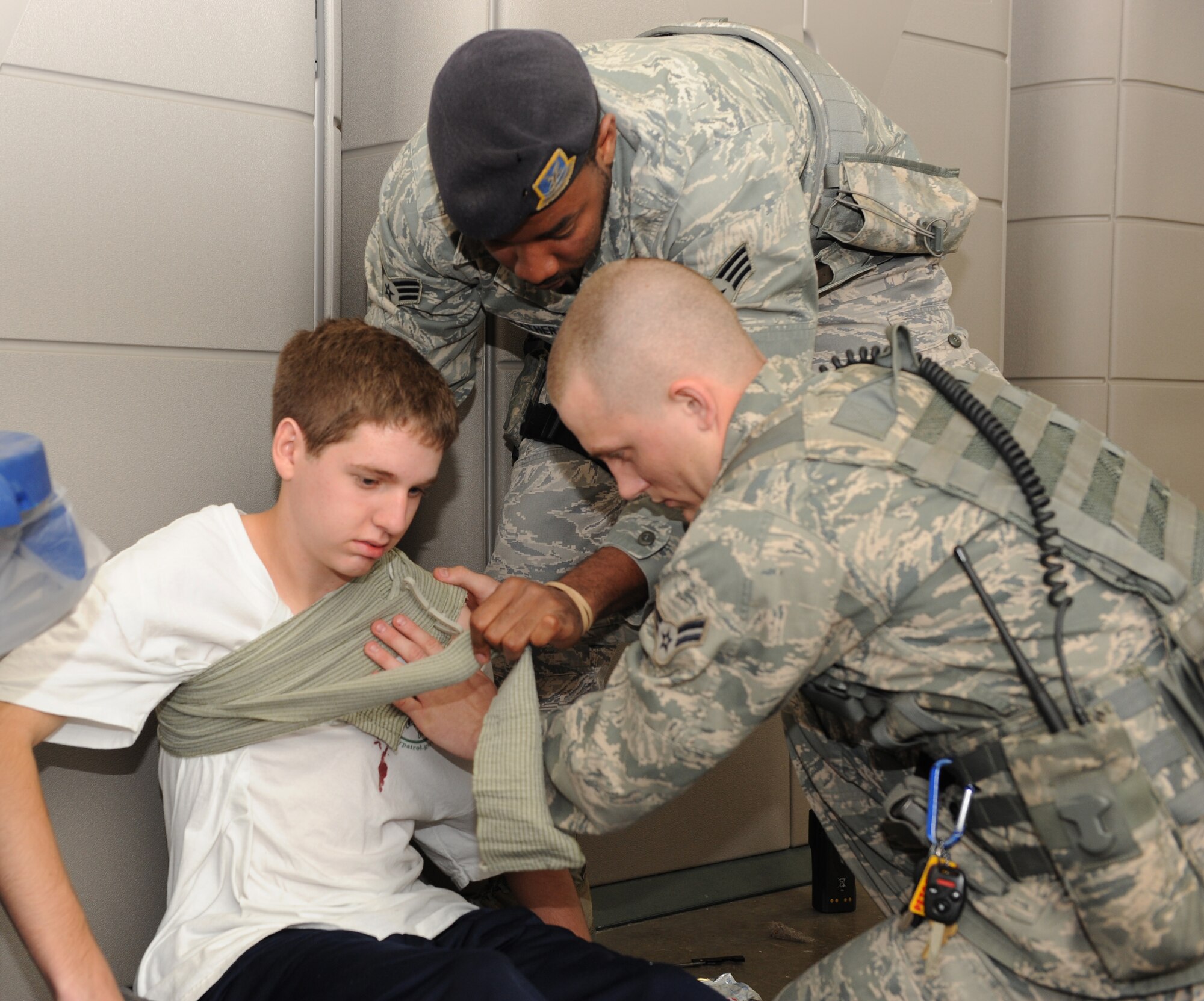 Senior Airman Miguel Merriweather (center) and Airman 1st Class Jaren Bishop, both 19th Security Forces Squadron patrolmen, help an injured victim during a major accident response exercise April 12, 2011, at Little Rock Air Force Base, Ark. The MARE enabled Airmen to practice procedures for the upcoming operation readiness inspection in October. (U. S. Air Force photo by Airman 1st Class Ellora Stewart)