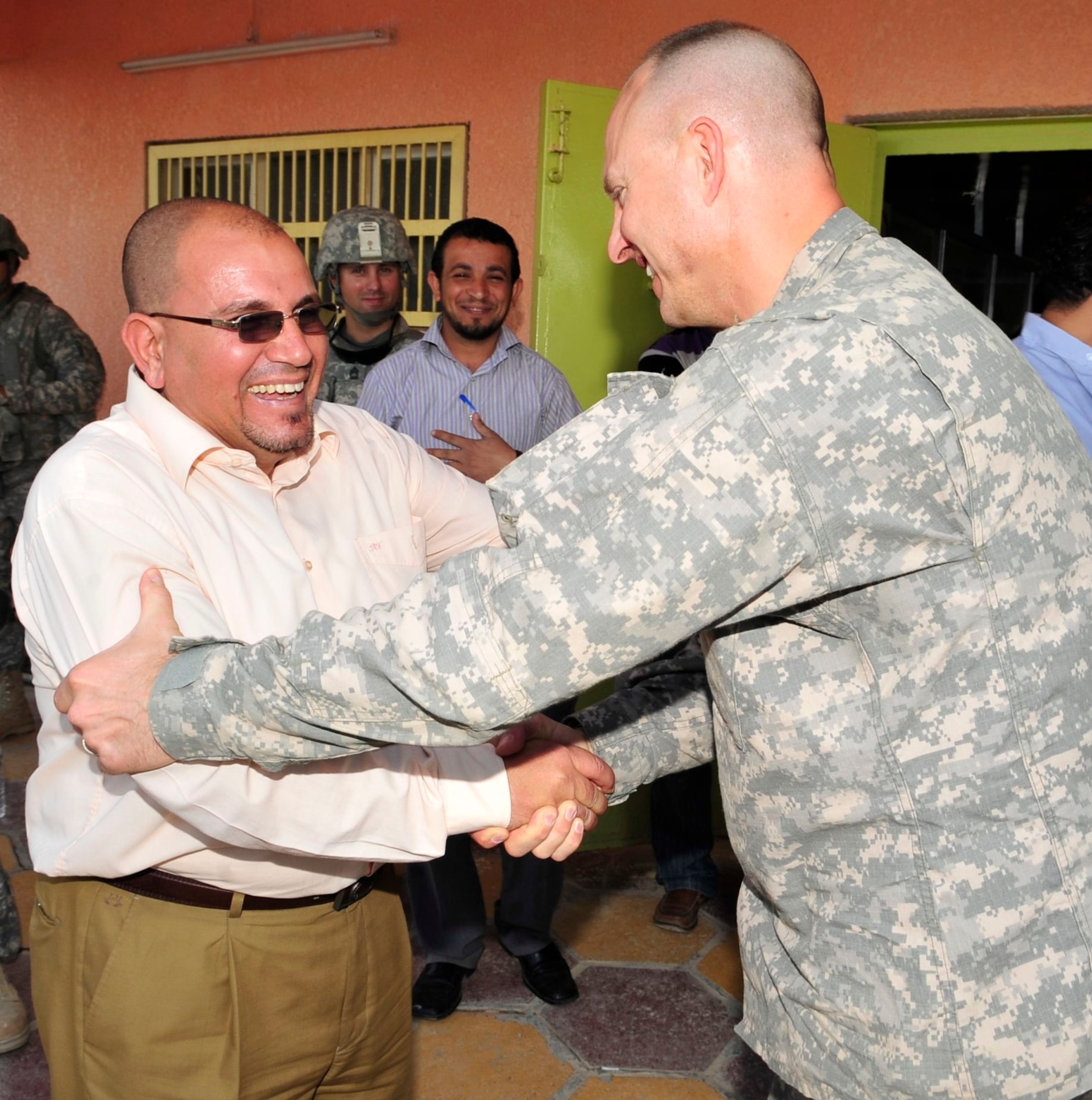 U.S. Army Capt. Mark Weber, U.S. Forces – Iraq corrections assistance transition team officer in charge, from Greenfield, Iowa, shakes hands with the prison warden at a facility in the Rusafa Prison Complex, Baghdad, Iraq, April 6, 2011. CATT members take notes as they ask questions and review conditions for inmates. (U.S. Air Force photo by Senior Master Sgt. Larry A. Schneck)