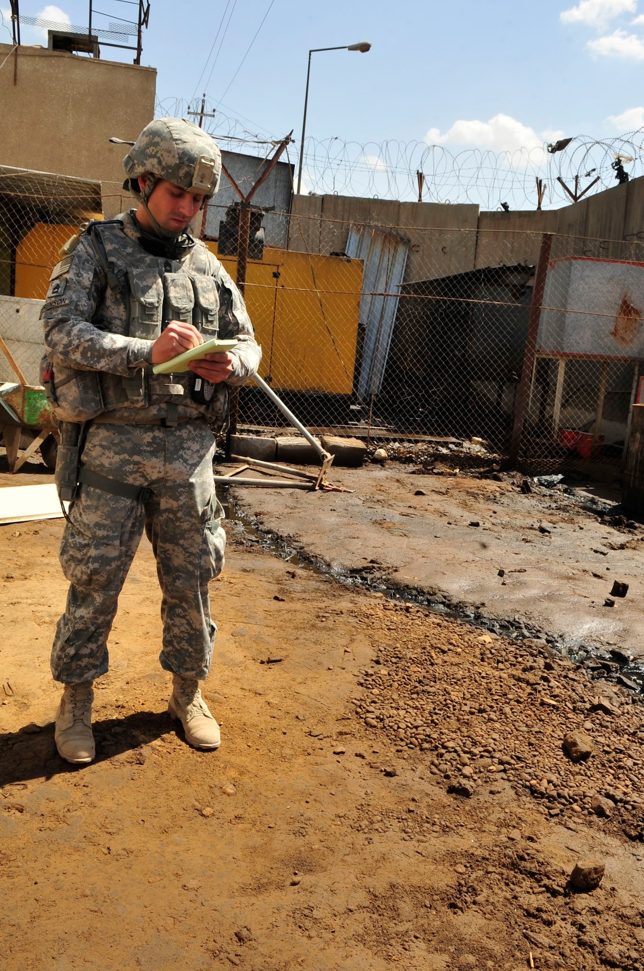 U.S. Army Sgt. 1st Class Todd Berenson, U.S. Forces – Iraq provost marshal office corrections assistance transition team force engineer assessor, takes notes outside near a power generator producing electricity for a prison in Baghdad’s Rusafa Prison Complex, April 6, 2011. Sergeant Berenson took note of an unsafe condition with fuel spillage coming from a tank next to the generator. He made his observation during an assessment of conditions at the facility. (U.S. Air Force photo by Senior Master Sgt. Larry A. Schneck)