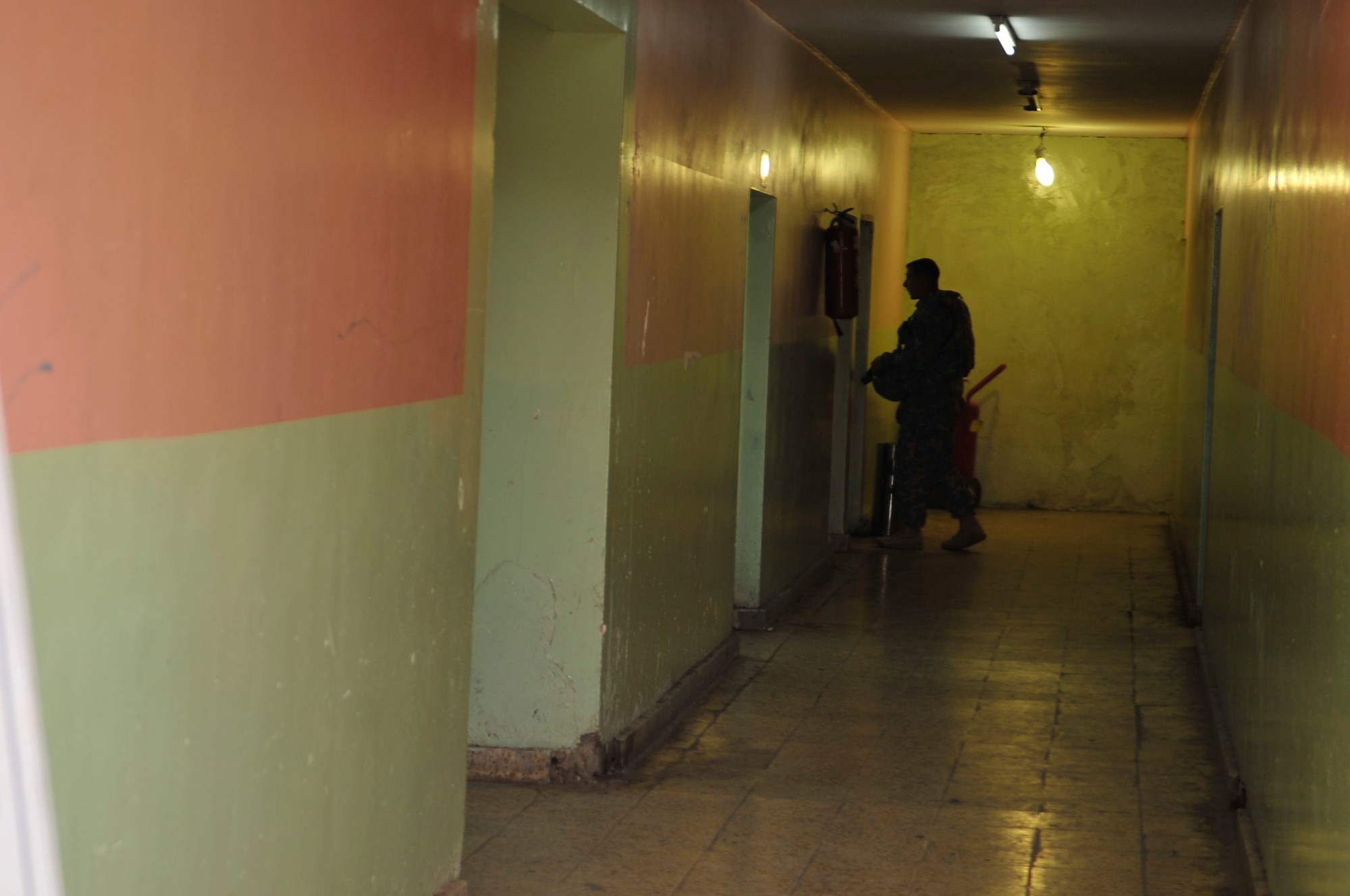 A U.S. Army Soldier and member of the U.S. Forces – Iraq corrections assistance transition team enters an office inside a facility at the Rusafa Prison Complex, Baghdad, Iraq, April 6, 2011. CATT is conducting an assessment of the health and welfare of prisoners under the care of the Government of Iraq. (U.S. Air Force photo by Senior Master Sgt. Larry A. Schneck)