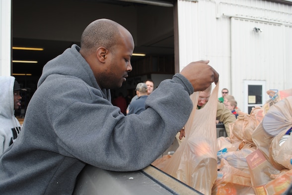 Senior Airman Reggie Manning, 341st Logistics Readiness Squadron supply member, helps empty a truck bed full of donated goods.  Airman Manning volunteered with other members of his Airman Leadership class. (U.S. Air Force photo/Airman Cortney Hansen)