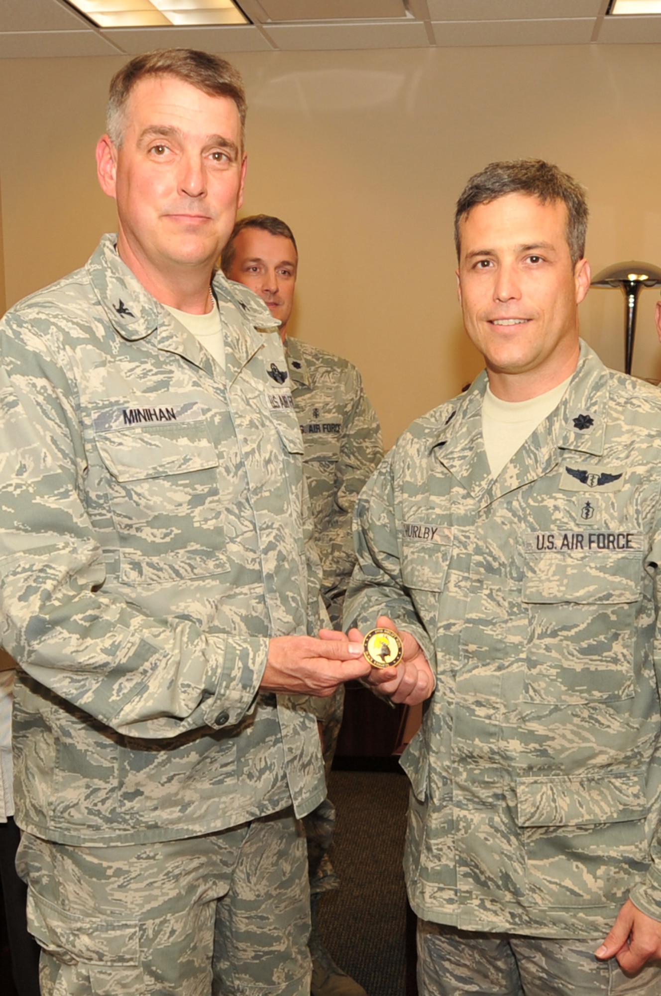 Col. Mike Minihan (left), 19th Airlift Wing commander, presents his commander’s coin to Lt. Col. Jefferson Thurlby, 19th Medical Group chief of medical staff, April 11, 2011, at Little Rock Air Force Base, Ark. Colonel Thurlby revitalized the group’s peer review process and reinstituted a mentoring program for junior providers. (U.S. Air Force photo/Airman 1st Class Rusty Frank)