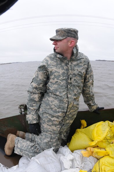 From right to left, Spc. Eric Wiederholt, Spc Joshua Lanzdorf, and Spc. Randy Birchfield, all of the 815th Engineer Company, Det. 2, based in Lisbon, N.D., carry sandbags in the rain, along a flood levee for placement in a flood barrier April 10, at a rural farmstead in Cass County, N.D.  The Soldiers are members of a North Dakota National Guard quick response force team that has been sent to the rural home, which has been surrounded by miles of flood water, by the Cass County tactical operations center. About 500 Guardsmen are currently conducting flood operations in North Dakota, with the vast majority in Cass County.
