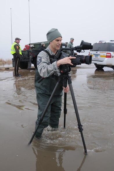 Master Sgt. Eric Johnson, of the 119th Wing, wades into floodwater April 9 to record a joint government agency evacuation from the flooded rural home of Obert Tenold near Harwood, N.D. As of Saturday April 9, about 480 N.D. Air and Army Guardsmen are conducting flood operations.
