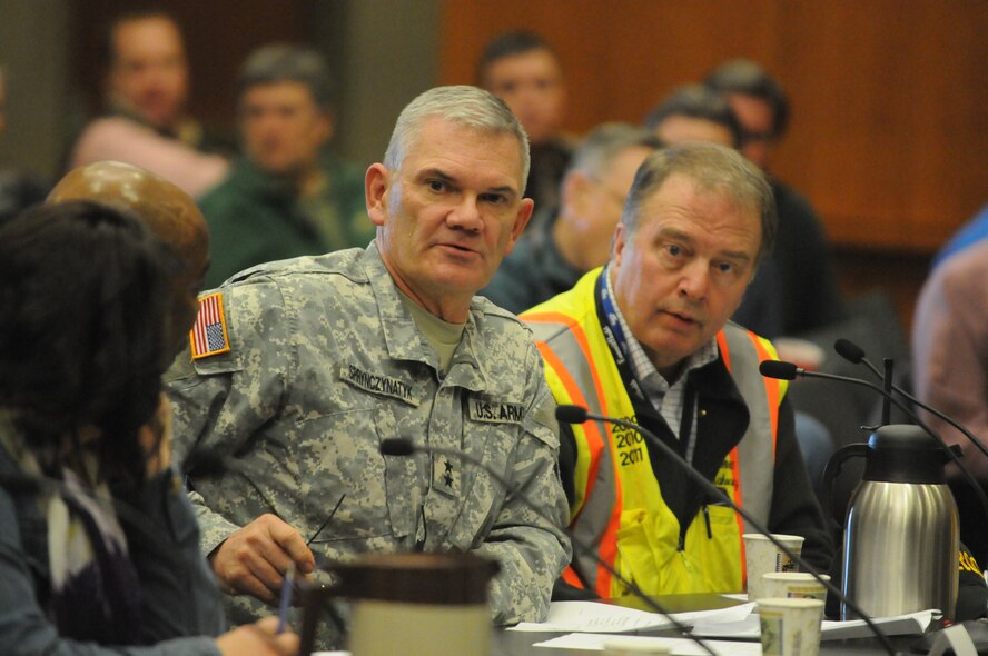Maj. Gen. David Sprynczynatyk, North Dakota adjutant general, contributes the N.D. National Guard perspective to the 2011 Red River Valley flood fight April 8 at the Fargo City Hall, Fargo, N.D.  Dr. Tim Mahoney, a Fargo City Commissioner, sits to the right of Sprynczynatyk. The Red River flood in the Fargo area is projected to be among the highest in city history.