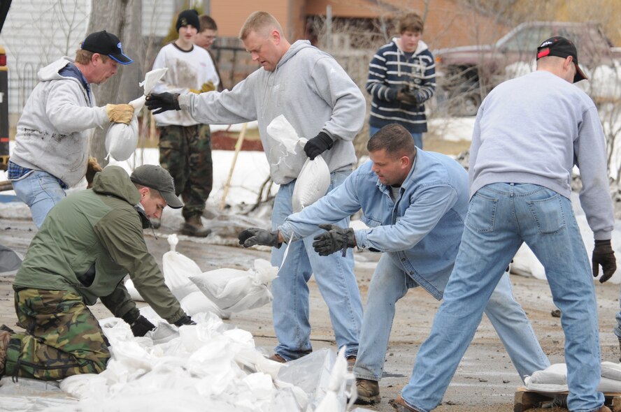 North Dakota Air National Guard volunteers place sandbags onto a ring dike levee April 7 north of Fargo, N.D., around the home of Senior Master Sgt. Sandi and Master Sgt. Charles Renville, who also are members of the North Dakota Air National Guard. A combination of civilian and National Guard volunteers showed up on their own time to make sure the home is safe from rising floodwaters.