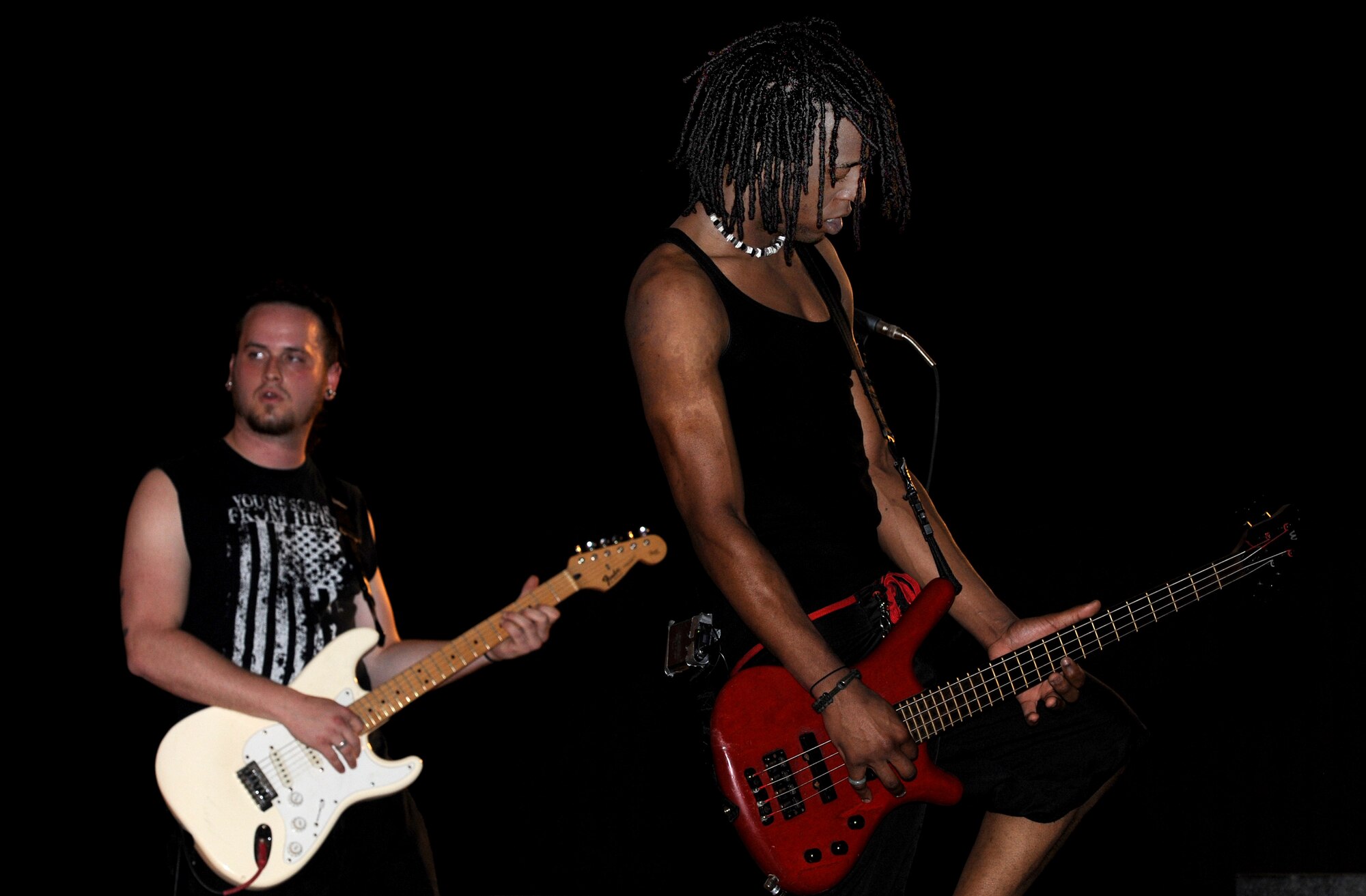 Lead guitarist Will Trenum and bass player Isaac Shields from the Along Those Lines alternative rock band, perform during an Armed Forces entertainment live show at Memorial Plaza, April 13 in Southwest Asia. (U.S. Air Force photo/Staff Sgt. Liliana Moreno)                            
