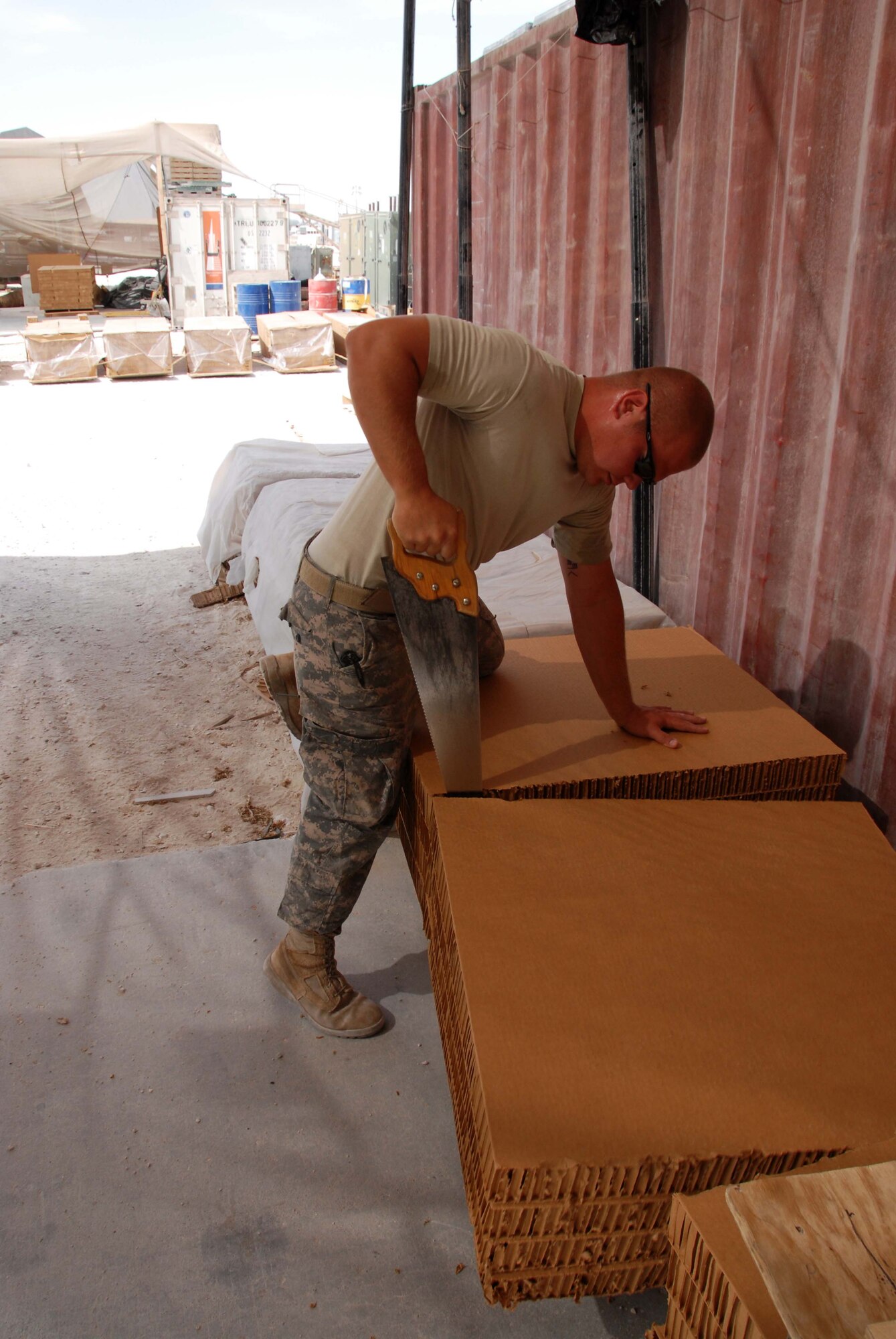 U.S. Army Spc. Shayne McKeever cuts a section of card board in Southwest Asia. The cardboard is commonly called “honeycomb” and is used to absorb the impact when the pallets land for troops down range. Specialist McKeever is assigned to the 824th Quartermaster Company Detachment 10 “Airborne Riggers”. (U.S. Air Force photo/Staff Sgt. Anthony Graham)