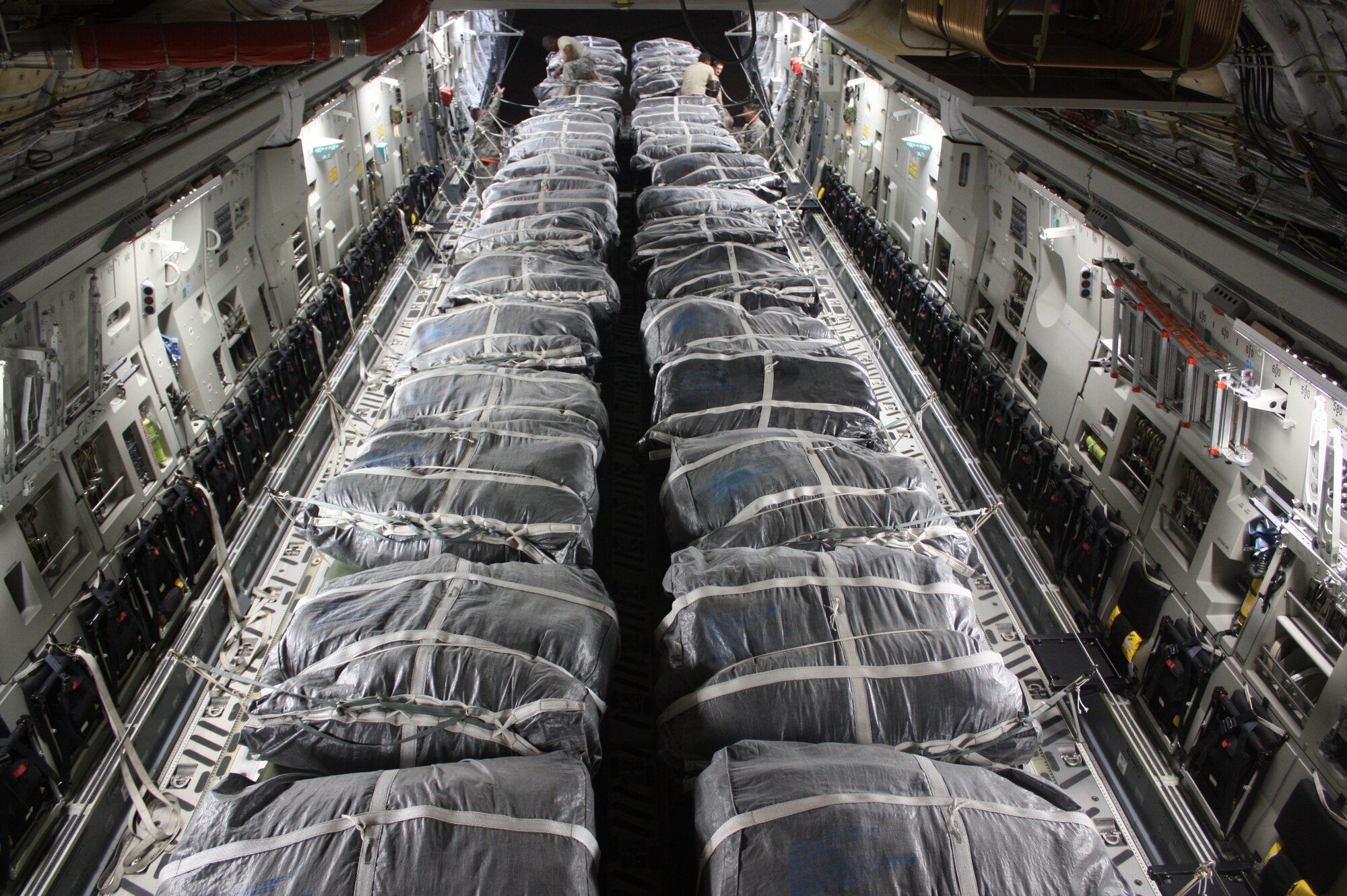 Servicemembers on a C-17 finish the final stages of preparing pallets for an air drop.  (U.S. Army photo/U.S. Army 1st Lt. Natalia Palumbo)