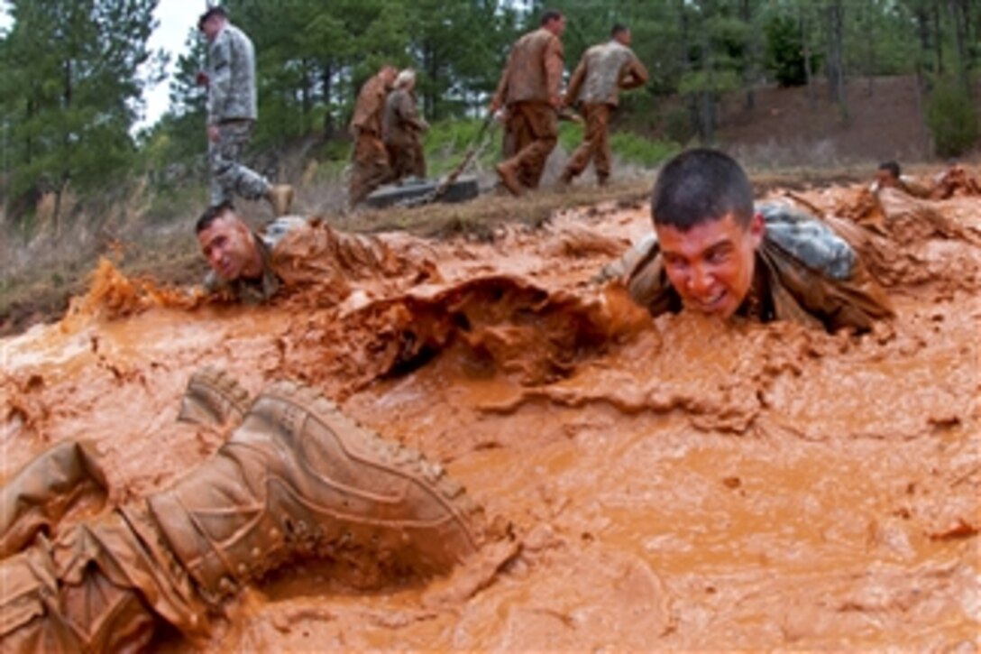 U.S. Army 1st Lt. Andrew McKinley crawls through a muddy obstacle as he and his team of officers complete a testing course during Prop Blast, a traditional team-building event that welcomes new officers to the division at Fort Bragg, N.C., on April 8, 2011.  McKinley is a logistics officer assigned to the 82nd Airborne Divisionís 1st Brigade Combat Team.  