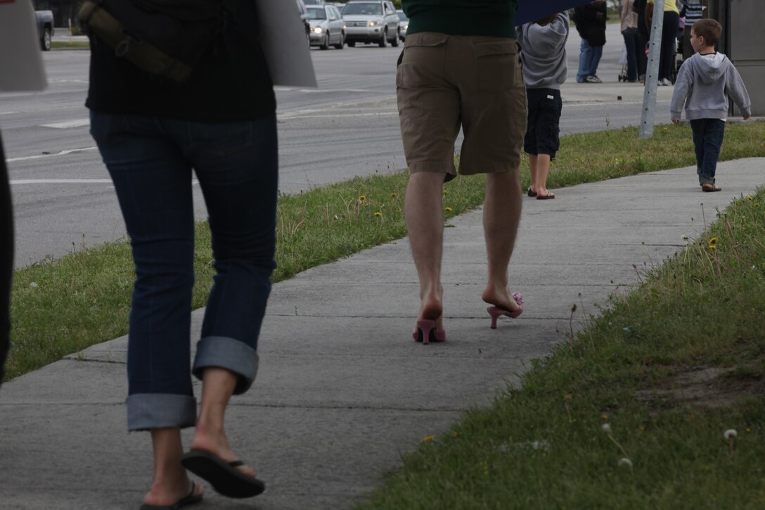 Staff Sgt. Justin Raack walks down Western Boulevard in high heels in his support for the fight against sexual assault during the “Walk a Mile in Her Shoes” march April 16. More than 150 people joined the march which is an opportunity for men to raise awareness in their community about the serious causes, effects and remediations to sexualized violence.  Raack is a combat instructor at Advanced Infantry Training Battalion, School of Infantry – East.