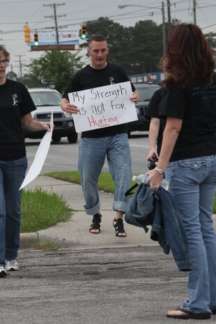 Staff Sgt. Jeremy Burns shows his support in high heels for the fight against sexual assault April 16 during the “Walk a Mile in Her Shoes” march on Western Boulevard. More than 150 people joined the march which is an opportunity for men to raise awareness in their community about the serious causes, effects and remediations to sexualized violence. Burns is a court reporter for Combat Logistics Regiment 27, 2nd Marine Logistics Group.::r::::n::::r::::n::