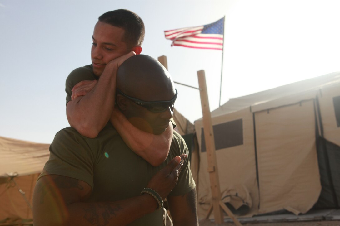 Gunnery Sgt. Christopher McDougal, the lead instructor of a battalion MCMAP course, demonstrates the proper technique for tapping out during practice drills for the figure-4 variation blood choke.   The Jackson, Miss., native made sure to emphasize safety with this drill because the choke is designed to make an enemy pass out in mere seconds.
