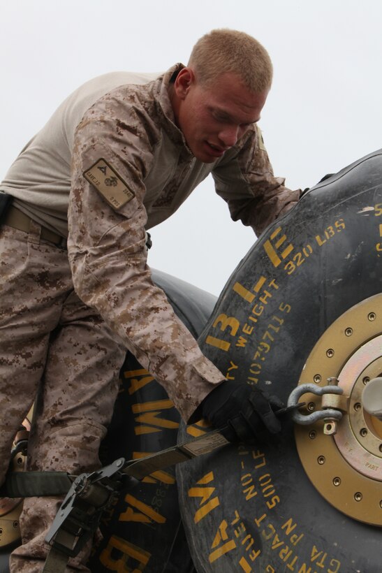 Lance Cpl. Jesiah D. Care, a motor transport operator with Marine Wing Support Squadron 272, unhooks a strap securing more than 2,500 gallons of jet propulsion fuel at a new forward arming and refueling point at Combat Outpost Ouellette in Afghanistan’s Helmand province, April 16. The forward arming and refueling point was recently constructed at the combat outpost to enable 2nd Marine Aircraft Wing (Forward) to better support Marines and other coalition troops operating near Sangin, Afghanistan. “I enjoy convoying,” said Care, a native of Reading, Pa. “I like being out here supporting the mission.”