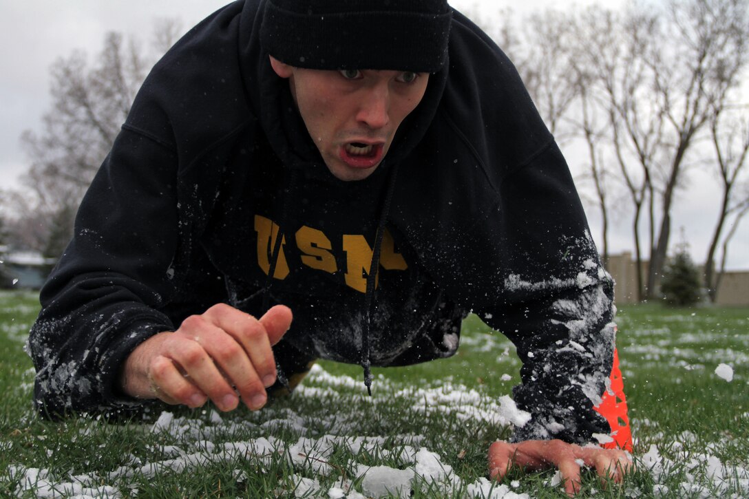 Jordan White, 19, from Farmington, Minn., low crawls through slush during the modified combat fitness test portion of Recruiting Substation Bloomington's Family Day April 16. Rain showers turned to flurries the night before the event, covering the area with one to two inches of snow. For more photos of the event, visit www.facebook.com/rstwincities.