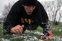 Jordan White, 19, from Farmington, Minn., low crawls through slush during the modified combat fitness test portion of Recruiting Substation Bloomington's Family Day April 16. Rain showers turned to flurries the night before the event, covering the area with one to two inches of snow. For more photos of the event, visit www.facebook.com/rstwincities.