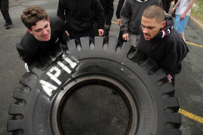 Michael Griepp, 19, from Apple Valley, Minn., and Justin Etheridge, 20, from Richfield, Minn., lift a 500-pound tractor tire during one of the training exercises at Recruiting Substation Bloomington's Family Day April 16.