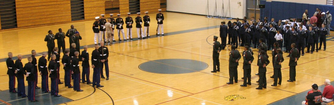 Four High School JROTC platoons stand in formations surrounding center court as they wait for announcement of the winner of a competition hosted by Recruiting Station St. Louis and judged by U.S. Marine Corps Silent Drill Platoon members April 16 at Seckman High School.