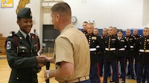 Cadet Charles Cormier accepts the first place trophy for the Sumner High School Army JROTC platoon during a drill competition hosted by Recruiting Station St. Louis and judged by U.S. Marine Corps Silent Drill Platoon members April 16 at Seckman High School. Cormier is the platoon commander of Sumner’s JROTC.