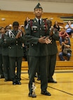 Cadet Charles Cormier stands proud with the 1st place trophy at his feet and his platoon behind him during a drill competition hosted by Recruiting Station St. Louis and judged by U.S. Marine Corps Silent Drill Platoon members April 16 at Seckman High School. Cormier is the platoon commander of the Sumner High School Army JROTC.