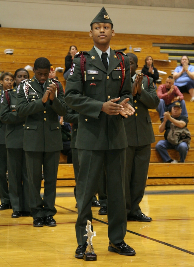 Cadet Charles Cormier stands proud with the 1st place trophy at his feet and his platoon behind him during a drill competition hosted by Recruiting Station St. Louis and judged by U.S. Marine Corps Silent Drill Platoon members April 16 at Seckman High School. Cormier is the platoon commander of the Sumner High School Army JROTC.