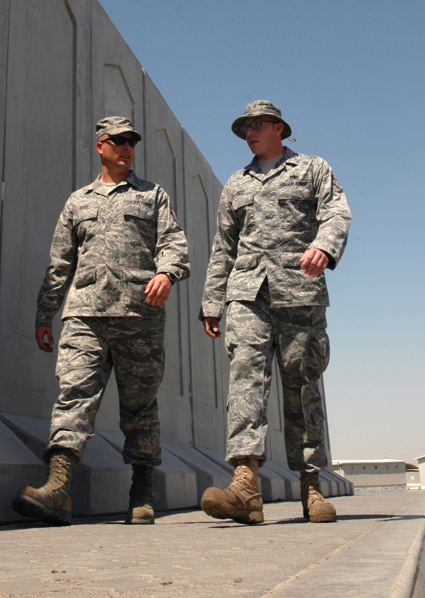 Senior Master Joseph Doss, 380th Expeditionary Civil Engineer Squadron, walks with his brother, Staff Sgt. Christopher Doss, 380th Expeditionary Aircraft Maintenance Squadron, whom he discovered recently during their current deployment to the same location in Southwest Asia. The two have been catching up on more than 24 years of lost time. (U.S. Air Force photo by Master Sgt. Julie Briden-Garcia)