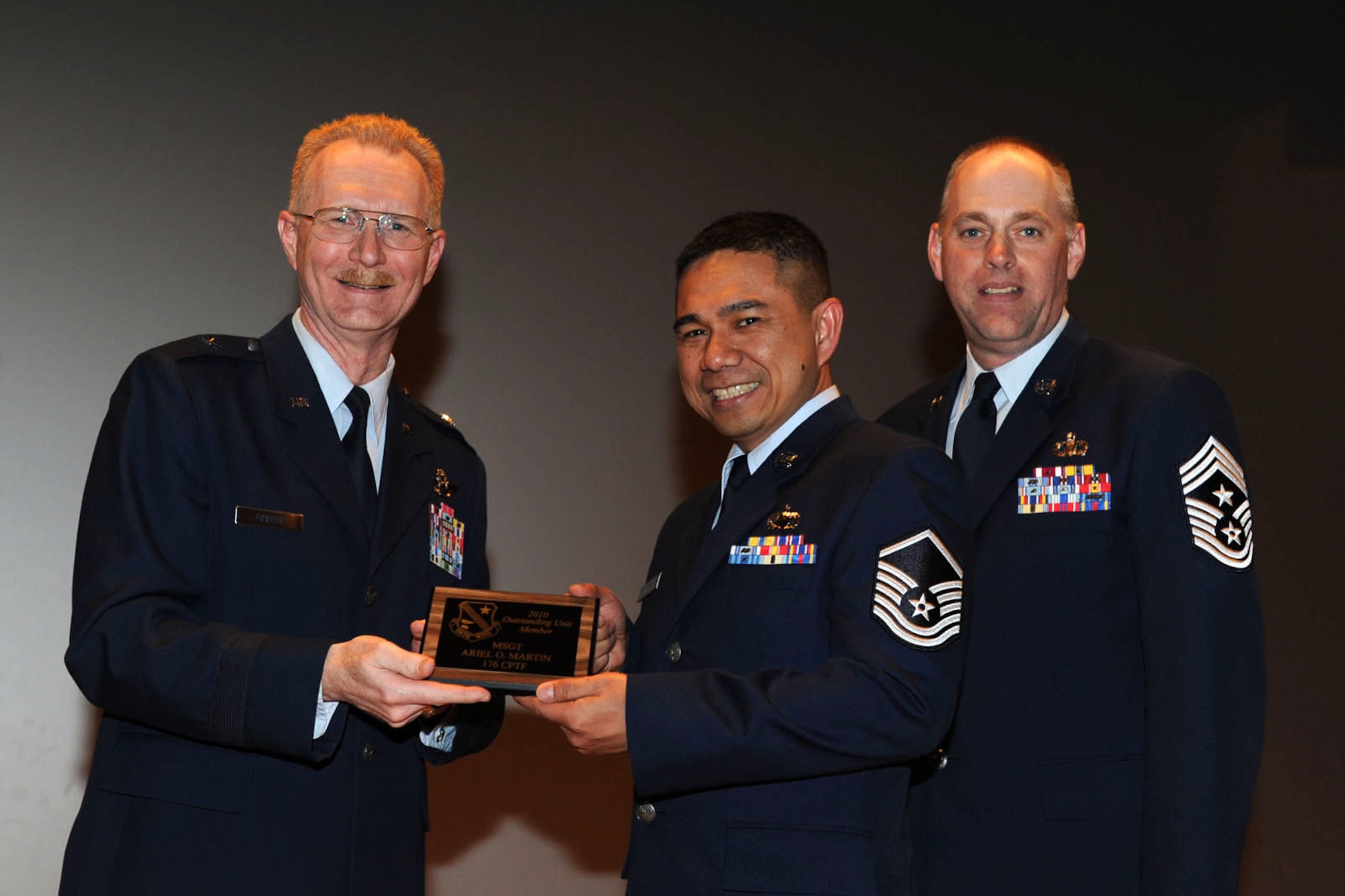 Joint Base Elmendorf-Richardson, Alaska ? Master Sgt. Ariel Martin, a staff accountant for the 176th Comptroller Flight, receives his award plaque from Brig. Gen. Charles Foster, commander of the 176th Wing and Chief Master Sgt. David Streit, command chief of the 176th Wing during the 176th Wing?s annual awards ceremony, Apr. 16, 2011.  Martin was the 2010 outstanding unit member of the year for the comptroller Flight. Alaska Air National Guard photo by Master Sgt. Shannon Oleson