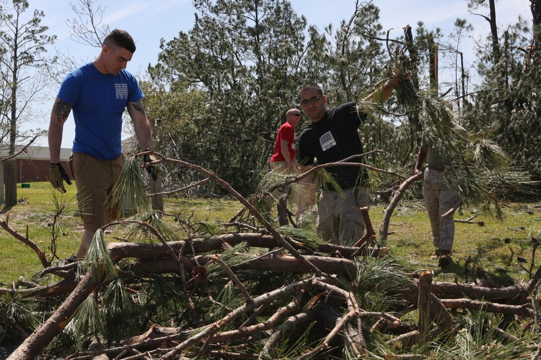 A working party of Marines and civilians clean up fallen tree branches and other debris from the side of the road aboard the Tarawa Terrace housing community, Marine Corps Base Camp Lejeune, April 15.