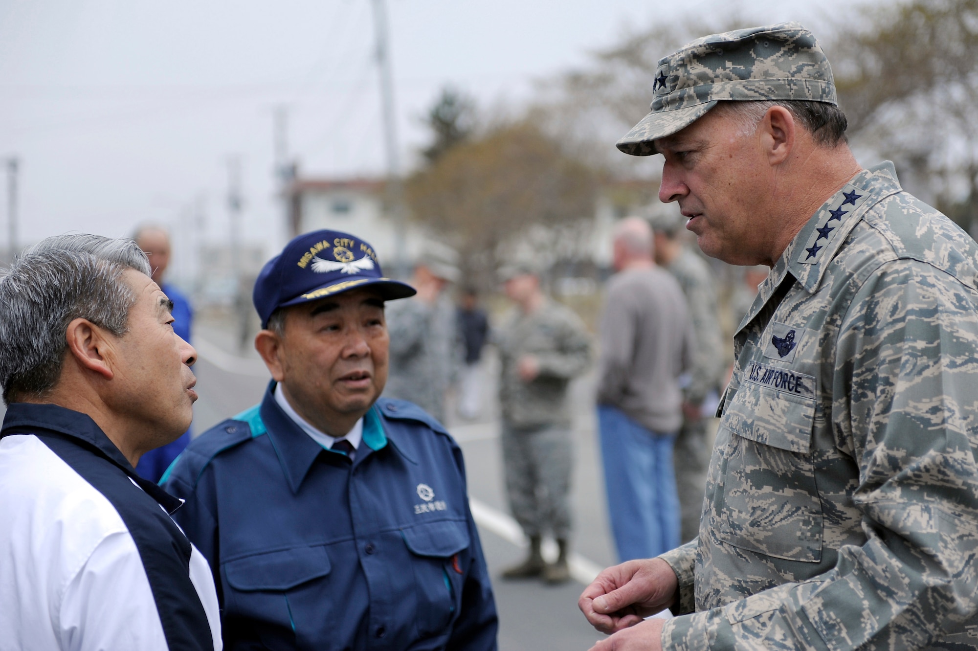 MISAWA AIR BASE, Japan -- Gen. Gary North, Pacific Air Forces commander, talks with Mr. Kazumasa Taneichi, Misawa City mayor, center, and Mr. Yukio Yamahata, interpreter, about the recovery progress during a recent visit April 16. General North visited the Misawa City Port to see the areas affected by the earthquake and learn about Misawa volunteer efforts. (U.S. Air Force photo by Staff Sgt. Marie Brown\Released)