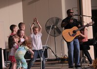 YOKOTA AIR BASE, Japan -- Children dance on the stage of Yokota's Sakura Shell as the band, Days Gone By, performs various rock songs during Tomodachi Stock 2011 here April 16. More than 700 people gathered at the free event to enjoy music and food while helping the American Red Cross raise money to support the earthquake and tsunami relief efforts. (U.S. Air Force photo/Senior Airman Andrea Salazar)
