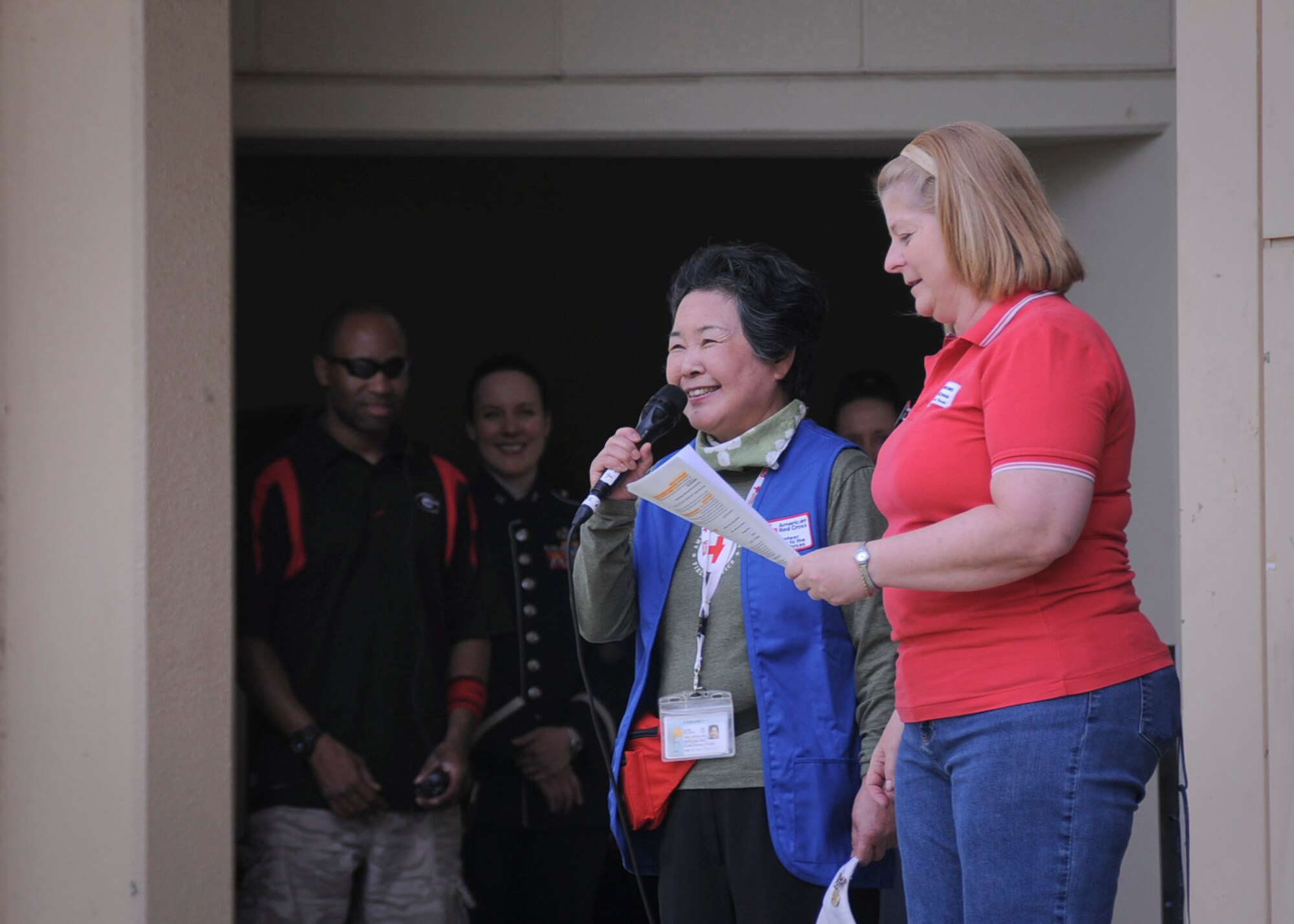 YOKOTA AIR BASE, Japan -- Tanaka Toshioko (left), chairman of the Japanese Red Cross Society in Akiruno, Japan, thanks Team Yokota for their continuing support for earthquake and tsunami relief efforts during Tomodachi Stock 2011 here April 16. The free benefit concert was designed to provide a venue for Yokota residents to donate to the American Red Cross. (U.S. Air Force photo/Senior Airman Andrea Salazar)