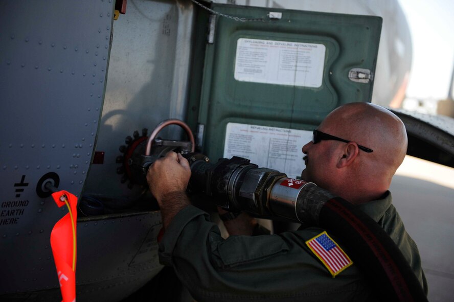 U.S. Air Force Master Sgt. Chuck Watkins, 115th Airlift Squadron, California Air National Guard, connects a fuel hose to a C-130J Hercules while preparing the aircraft for firefighting operations at Dyess Air Force Base, Texas, April 18, 2011.  The C-130 is equipped with the Modular Airborne Firefighting System (MAFFS) which is capable of dispensing 3,000 gallons of water or fire retardant in under 5 seconds.  (U.S. Air Force Photo/Staff Sgt. Eric Harris)