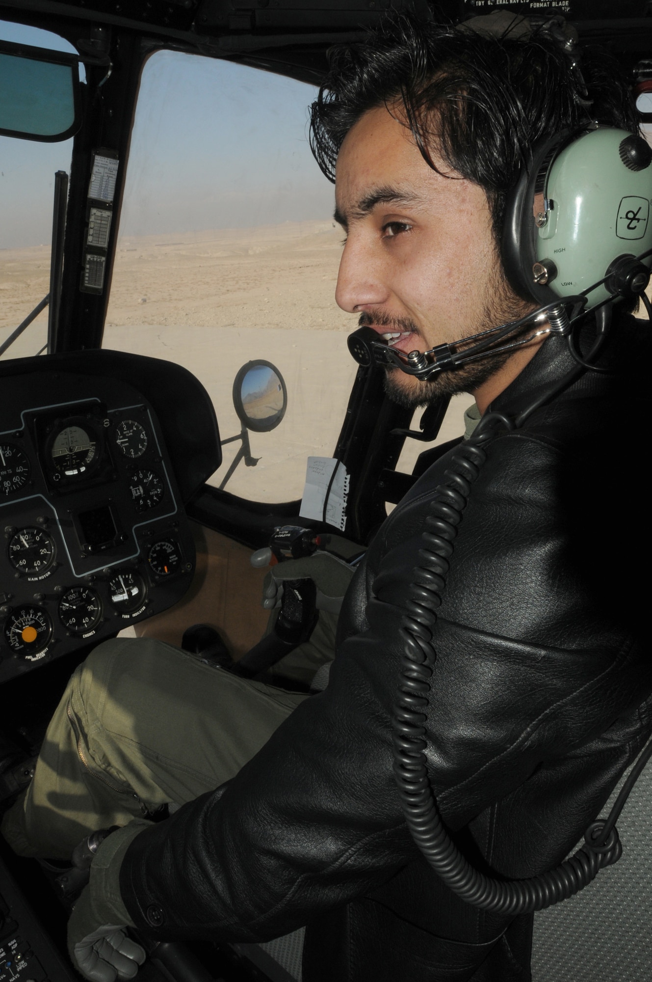 Afghan air force 1st Lt. Ahmad Fawad Haidari looks at his instructor pilot during a training flight April 7, 2011, outside of Kabul. Lieutenant Haidari and 1st Lt. Abdul Saboor Amin, the first two Afghan helicopter pilots to go through basic aviator training in the U.S., recently became co-pilot qualified in the Mi-17. (U.S. Navy photo/Petty Officer 2nd Class Vladimir Potapenko)