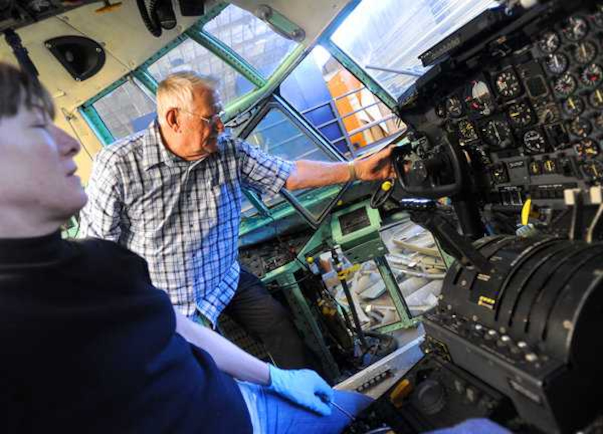 McChord Air Museum volunteers Jim Bernethy and Sherri Jenne look for a control inside the cockpit of a Lockheed C-130 Hercules that is being restored at the restoration hangar on March 25 at McChord Field, Joint Base Lewis-McChord, Wash. (U.S. Air Force photo/Ingrid Barrentine)