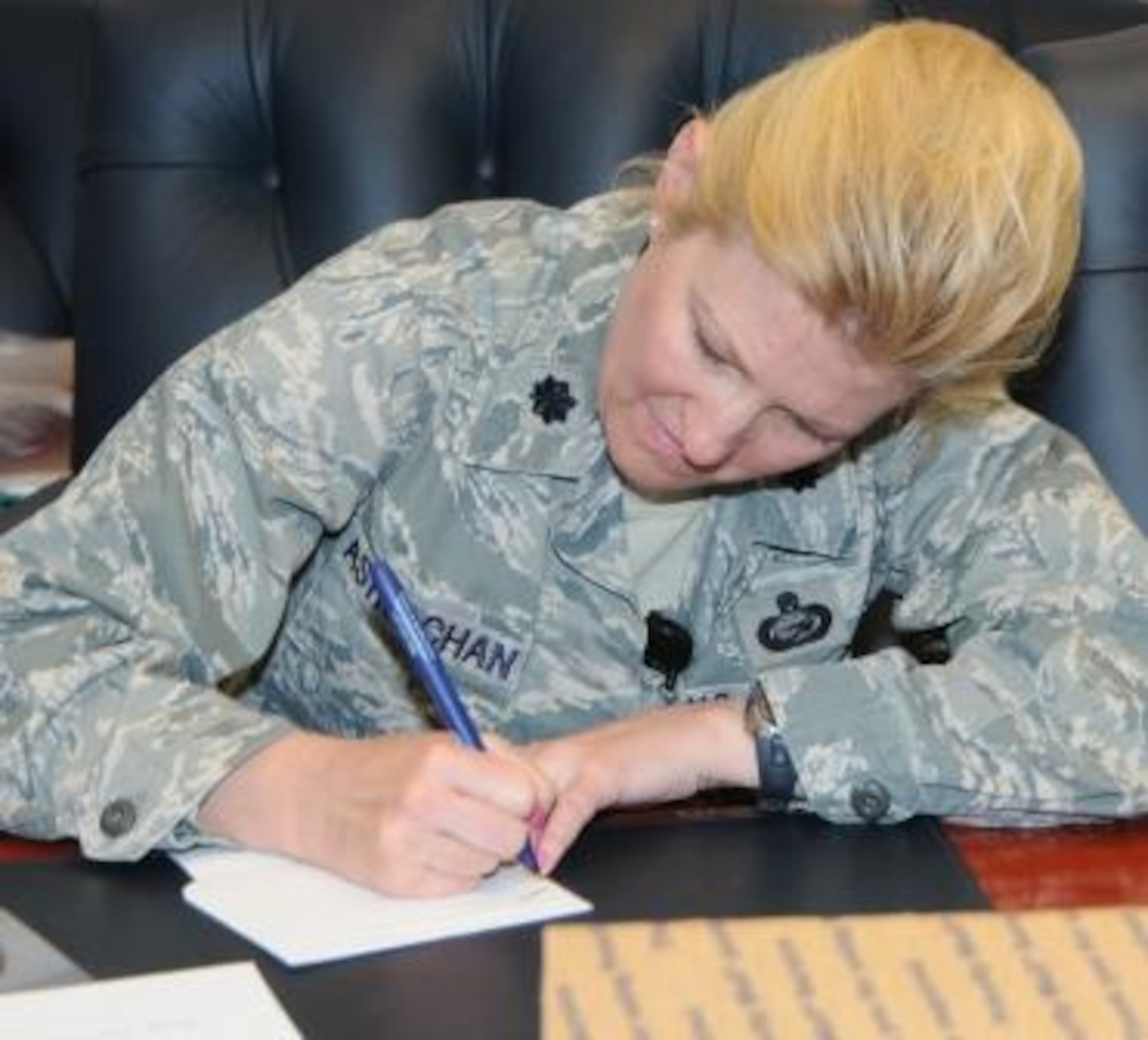 Lt. Col. Juliana Astrachan, Air Force Operational Test and Evaluation Center Director of Manpower and Personnel, writes a personal note to a deployed team member to be included in a care package.